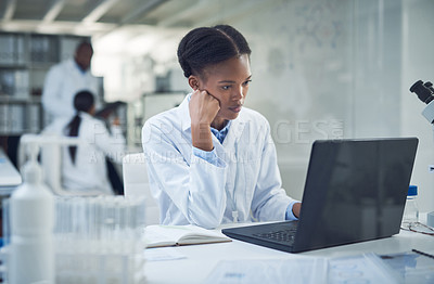 Buy stock photo Shot of a young scientist using a laptop while conducting research in a laboratory
