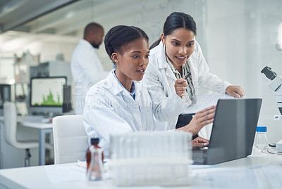 Buy stock photo Shot of two young scientists using a laptop in a laboratory