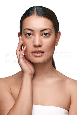 Buy stock photo Shot of a beautiful young woman touching her face while standing against a white background