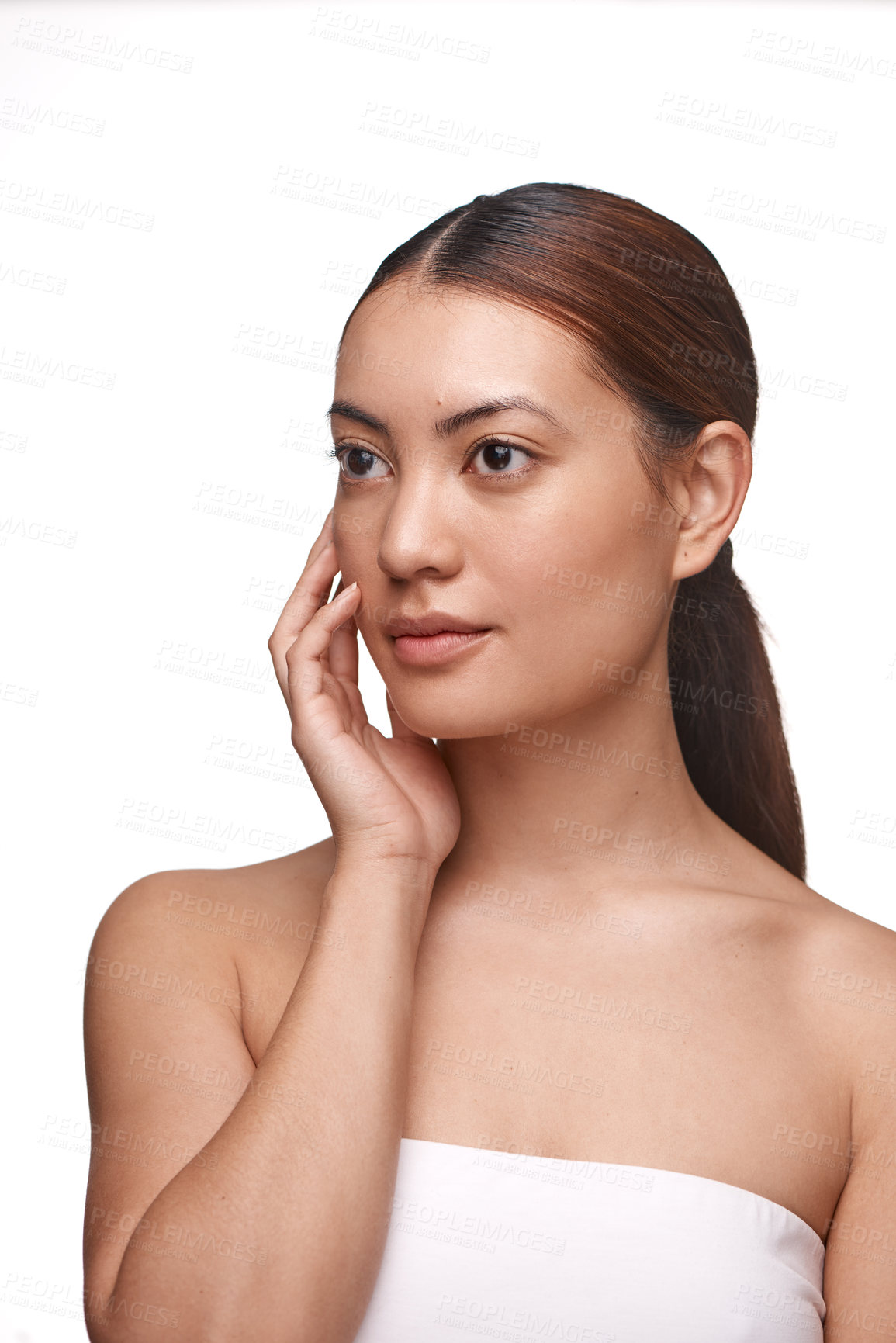 Buy stock photo Shot of a beautiful young woman touching her face while standing against a white background