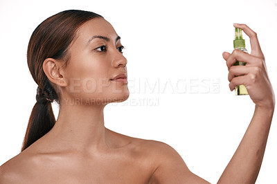 Buy stock photo Shot of a beautiful young woman holding up a bottle of face mist