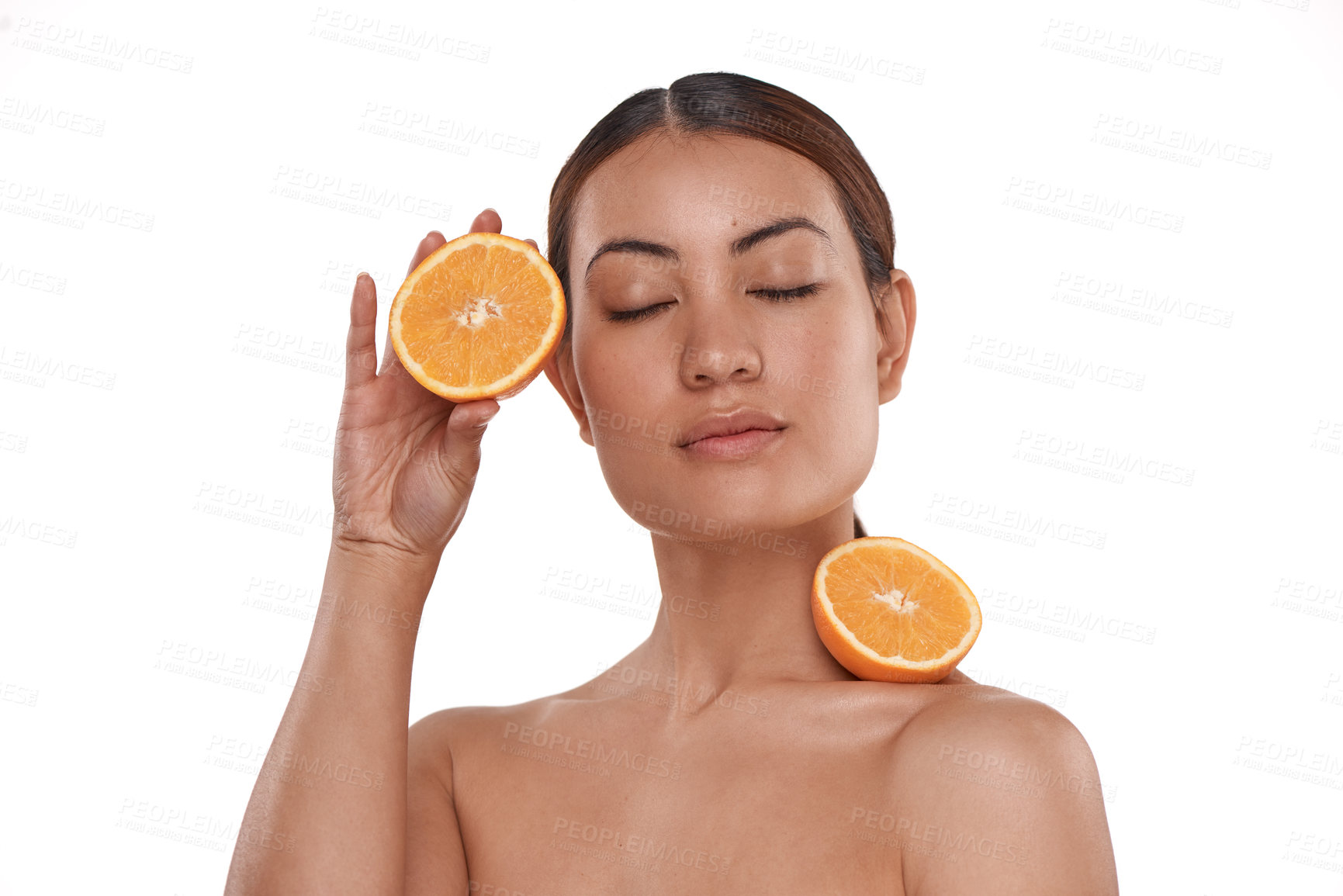 Buy stock photo Shot of a beautiful young woman posing with halved oranges against her skin