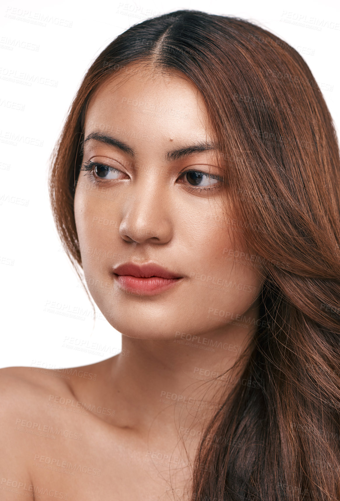 Buy stock photo Studio shot of a beautiful young woman with long brown hair against a white background