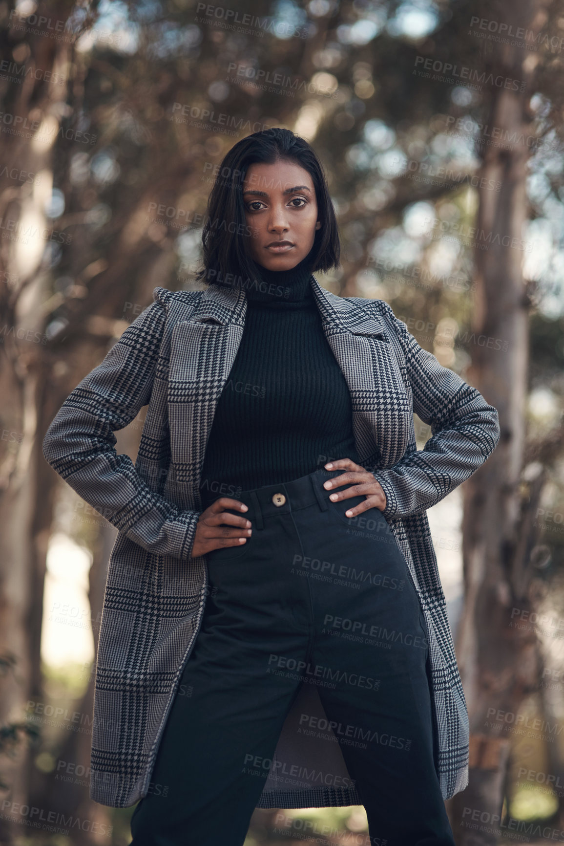 Buy stock photo Shot of a fashionable young woman posing against a nature background