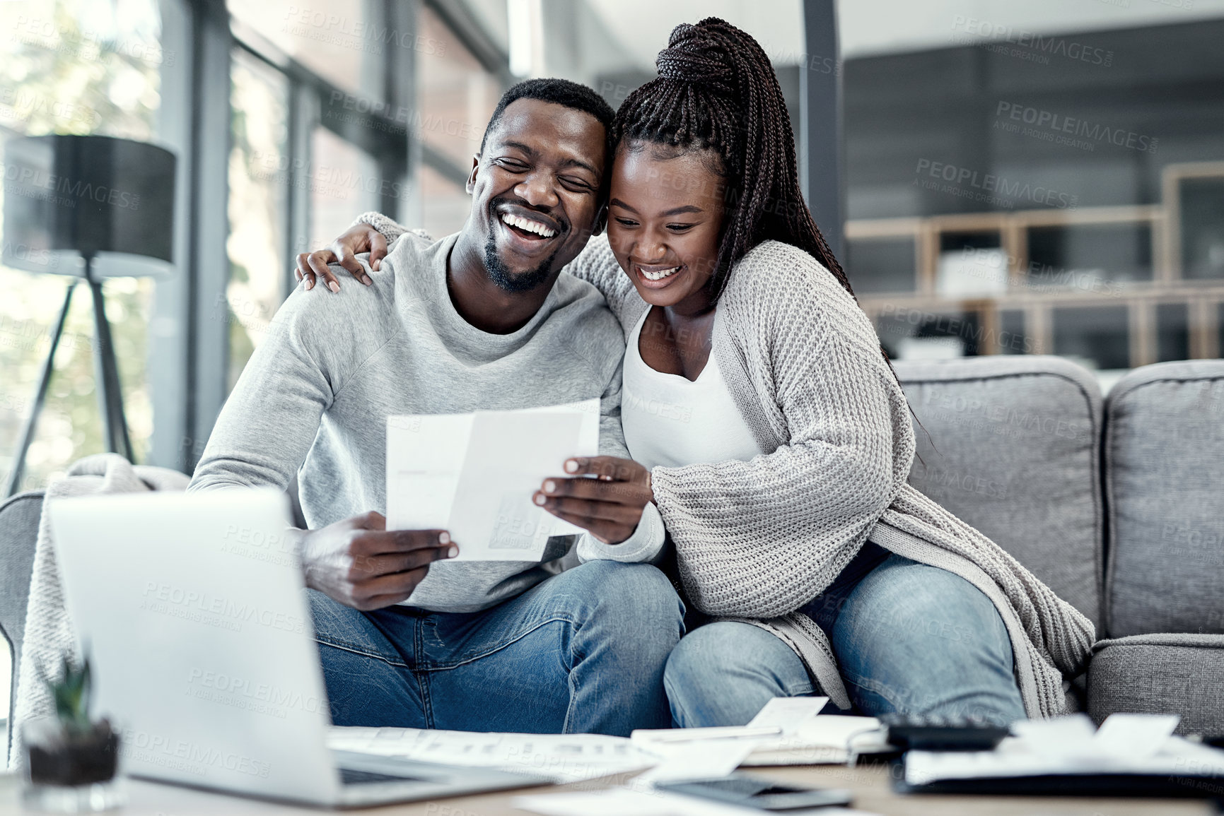 Buy stock photo Shot of an affectionate young couple going through paperwork at home