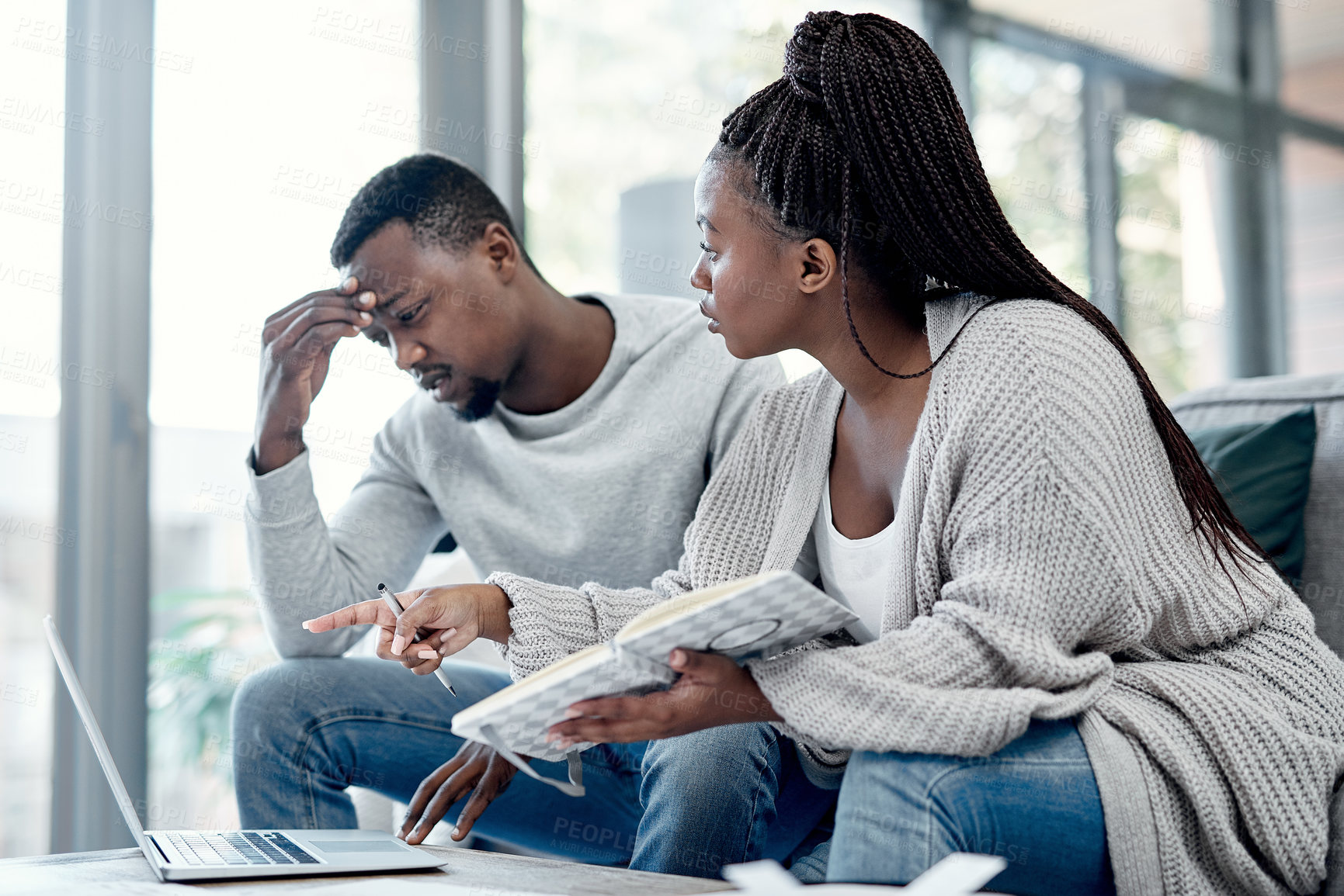 Buy stock photo Shot of a young couple having an argument while working on their finances at home