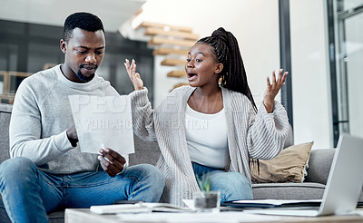 Buy stock photo Shot of a young couple having an argument while working on their finances at home