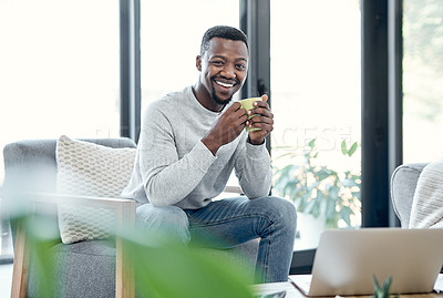 Buy stock photo Shot of a young man having a relaxing coffee break on the sofa at home