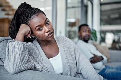 Buy stock photo Shot of a young couple ignoring each other after having an argument on the sofa at home