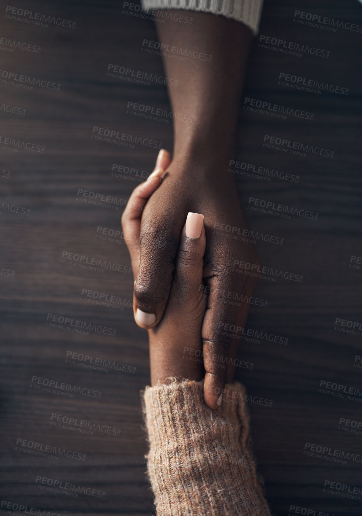 Buy stock photo Cropped shot of an unrecognizable couple holding hands while at home during the day