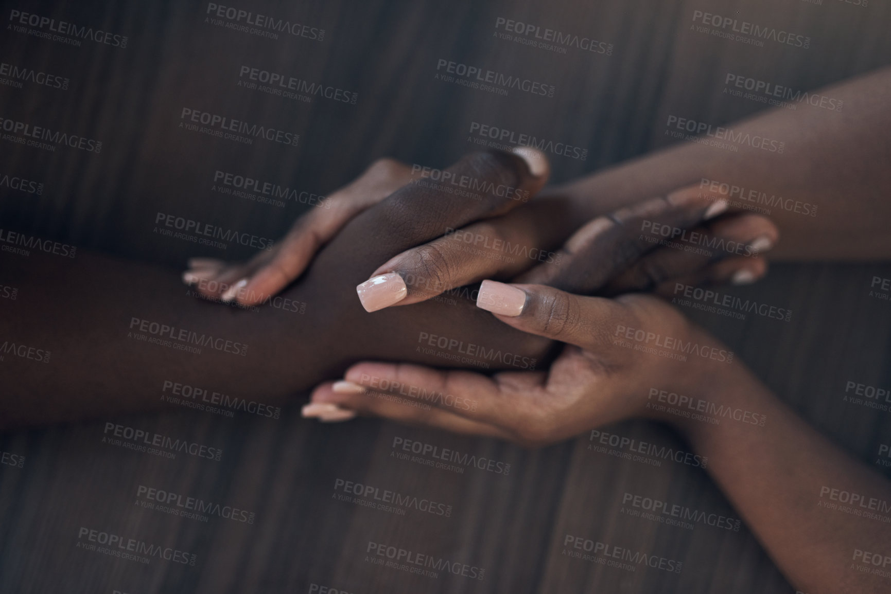 Buy stock photo Cropped shot of an unrecognizable couple holding hands while at home during the day