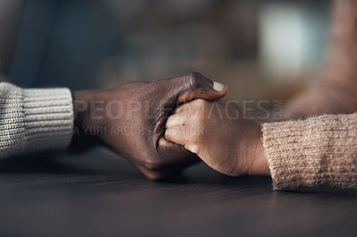 Buy stock photo Cropped shot of an unrecognizable couple holding hands while at home during the day