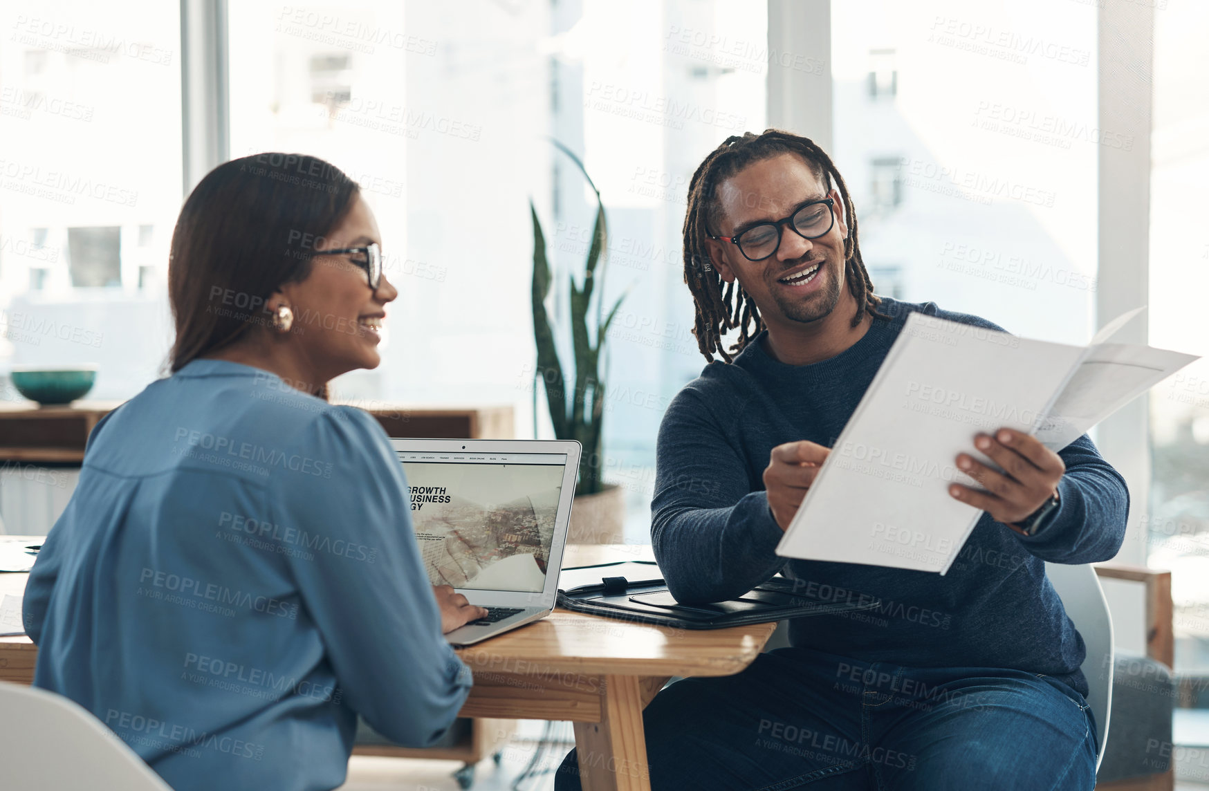 Buy stock photo Shot of two businesspeople going through paperwork together in an office