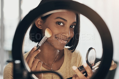 Buy stock photo Shot of a young woman applying makeup while filming a beauty tutorial at home