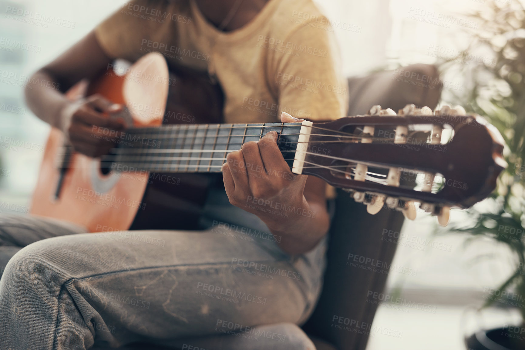 Buy stock photo Shot of an unrecognisable woman playing the guitar at home