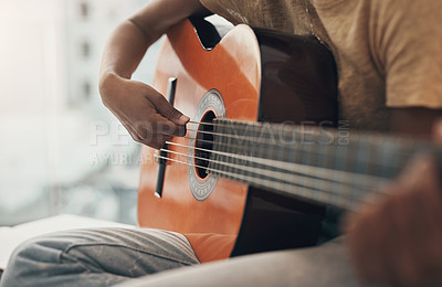 Buy stock photo Shot of an unrecognisable woman playing the guitar at home