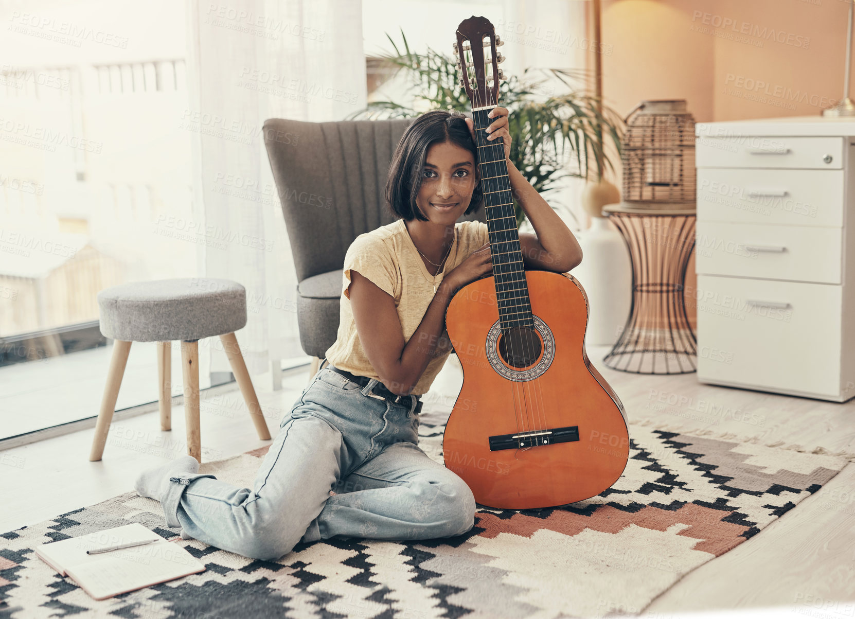 Buy stock photo Portrait of a young woman playing the guitar at home