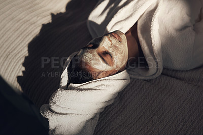 Buy stock photo Shot of a young woman giving herself a facial at home