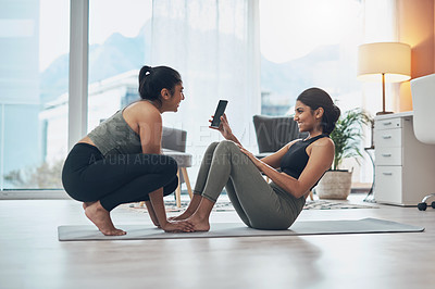 Buy stock photo Shot of two beautiful young women exercising together at home