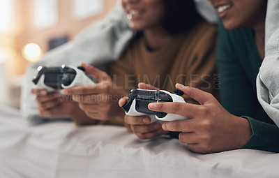 Buy stock photo Shot of two young women playing video games at home
