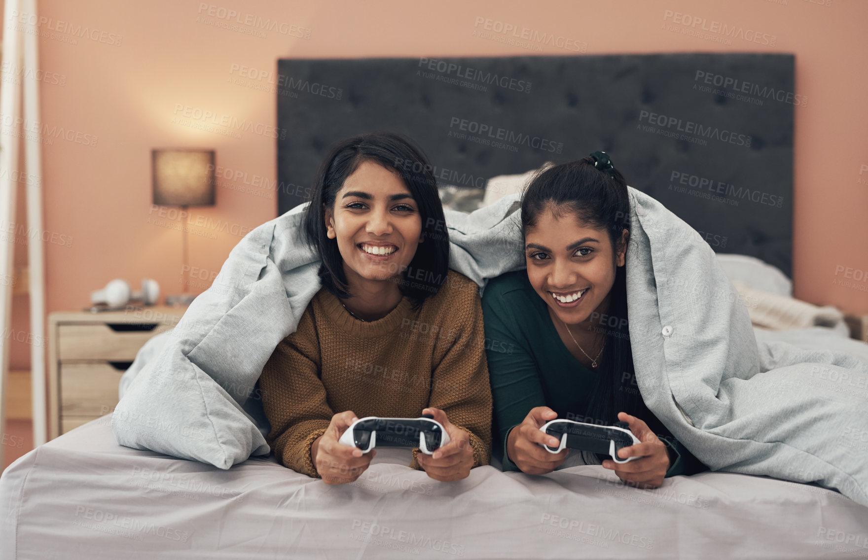 Buy stock photo Shot of two young women playing video games at home