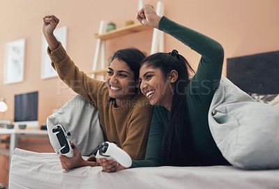 Buy stock photo Shot of two young women playing video games at home