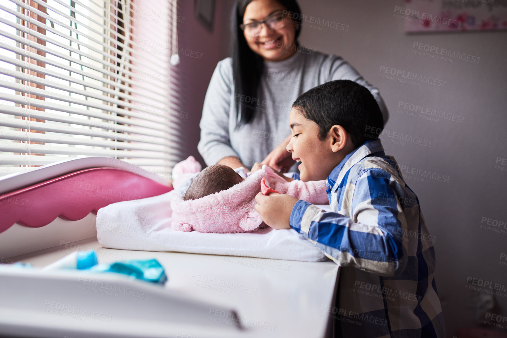 Buy stock photo Shot of an adorable little boy bonding with his newborn sister in the bedroom at home