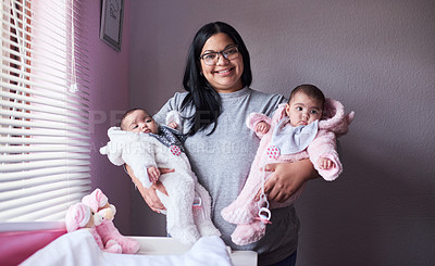 Buy stock photo Shot of a young woman carrying her twin baby girls at home