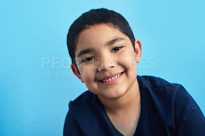 Buy stock photo Studio portrait of an adorable little boy posing against a blue background