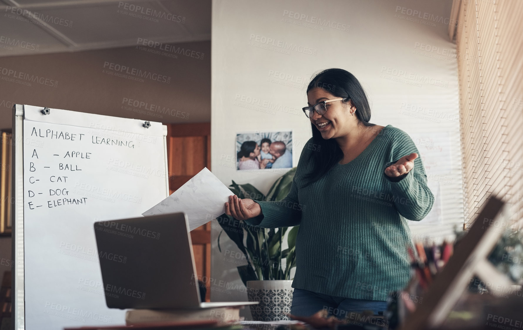 Buy stock photo Shot of a young woman using a laptop to teach a lesson from home