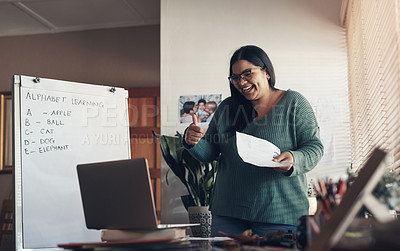 Buy stock photo Shot of a young woman giving a thumbs up and using a laptop to teach a lesson from home