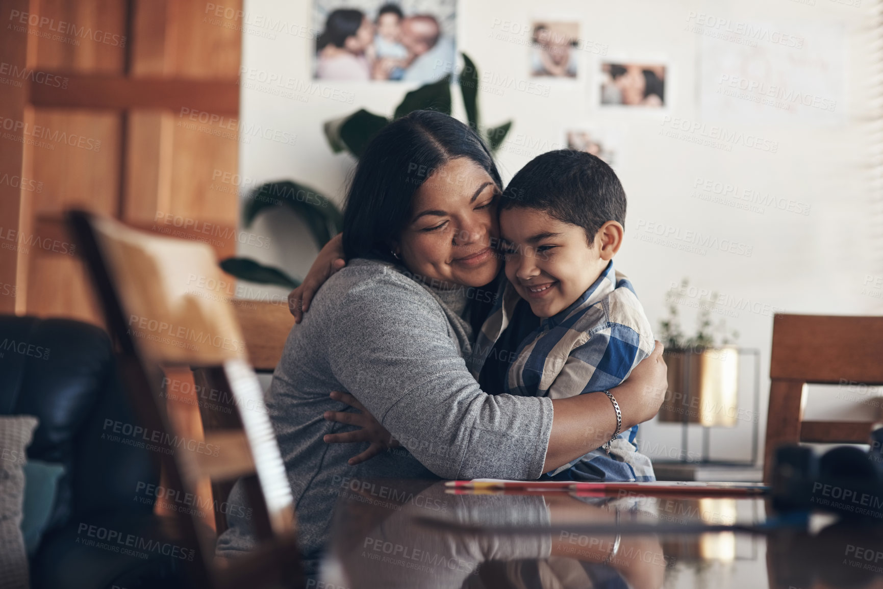 Buy stock photo Shot of an adorable little boy completing a school assignment with his mother at home