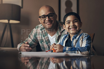 Buy stock photo Portrait of an adorable little boy completing a school assignment with his father at home
