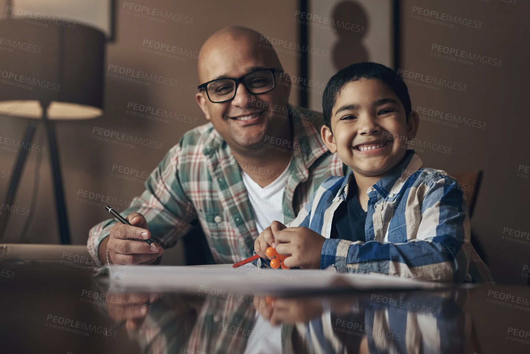 Buy stock photo Portrait of an adorable little boy completing a school assignment with his father at home