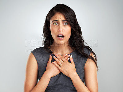 Buy stock photo Shot of a young woman looking surprised while posing against a white background