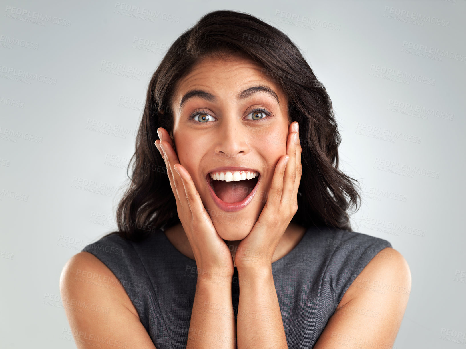 Buy stock photo Shot of a young woman looking surprised while posing against a white background