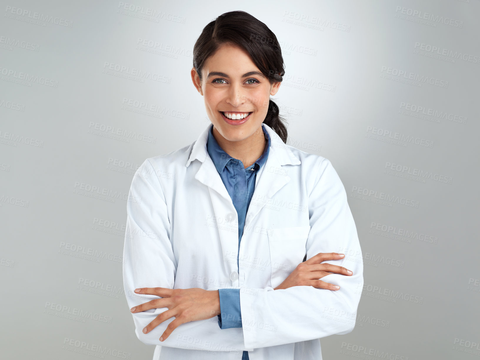 Buy stock photo Studio portrait of a confident young doctor posing against a grey background