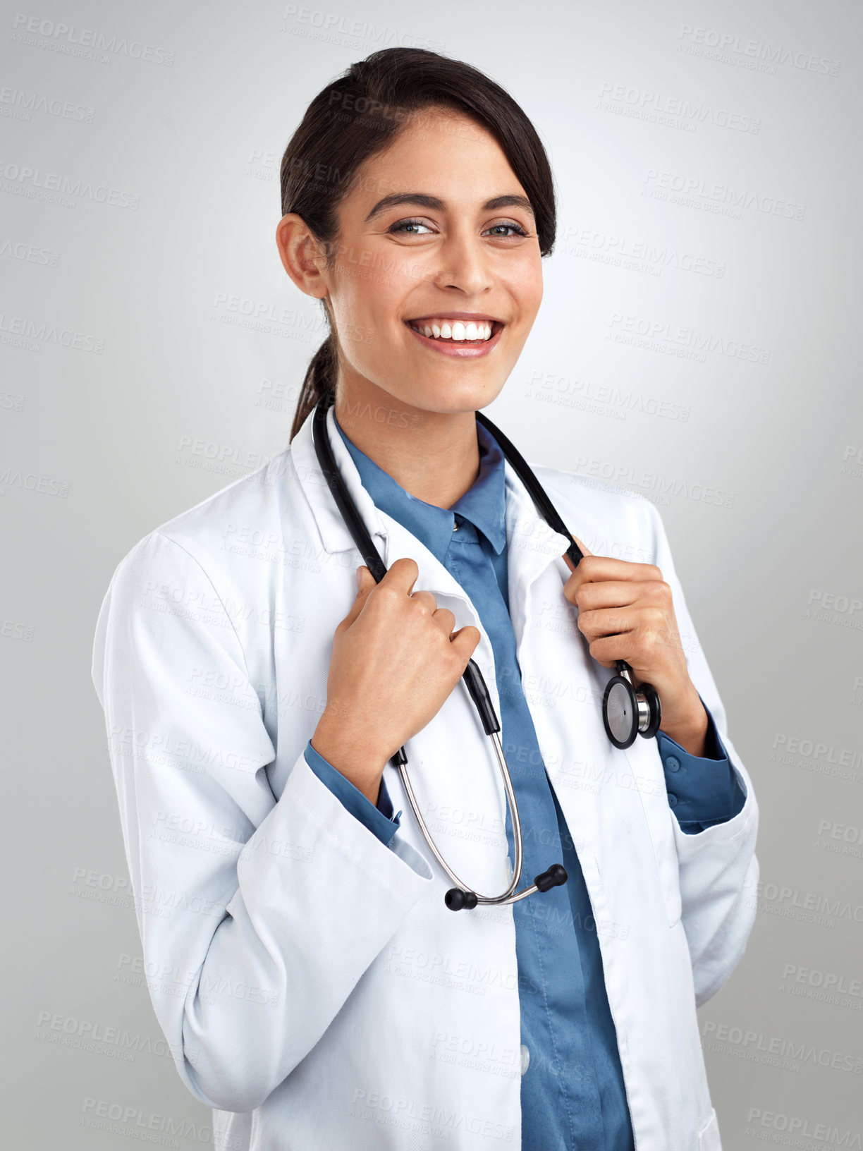 Buy stock photo Studio portrait of a confident young doctor posing against a grey background