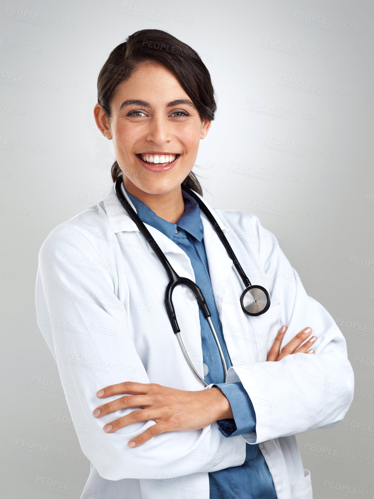 Buy stock photo Studio portrait of a confident young doctor posing against a grey background