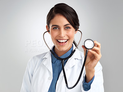 Buy stock photo Studio shot of a young doctor using a stethoscope against a grey background