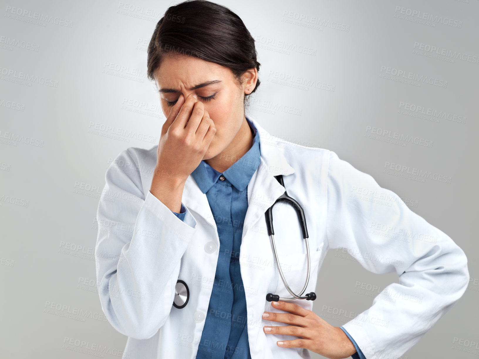 Buy stock photo Studio shot of a young doctor experiencing stress against a grey background