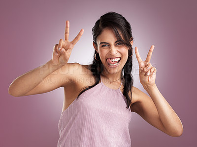 Buy stock photo Shot of a beautiful cheeky young woman showing the peace sign against a pink background