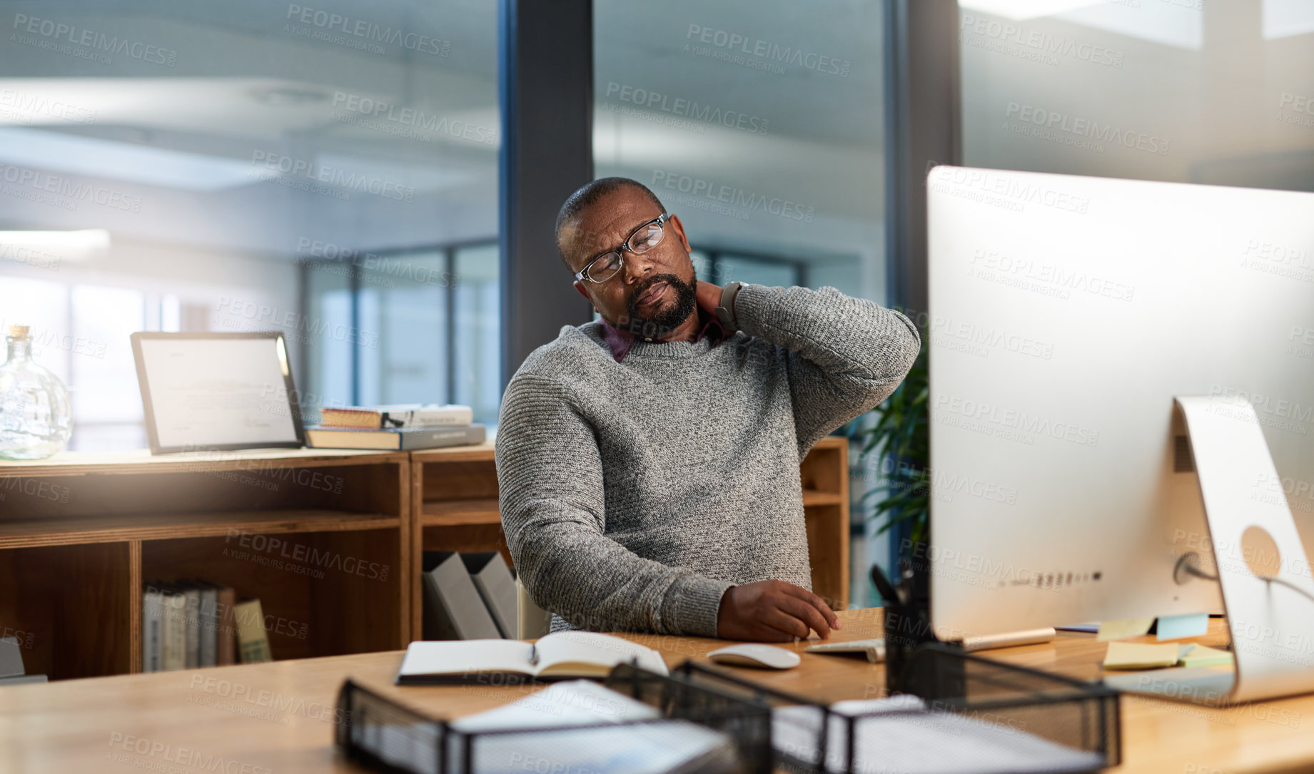 Buy stock photo Cropped shot of a handsome mature businessman sitting at his desk and suffering from neck ache during a late shift
