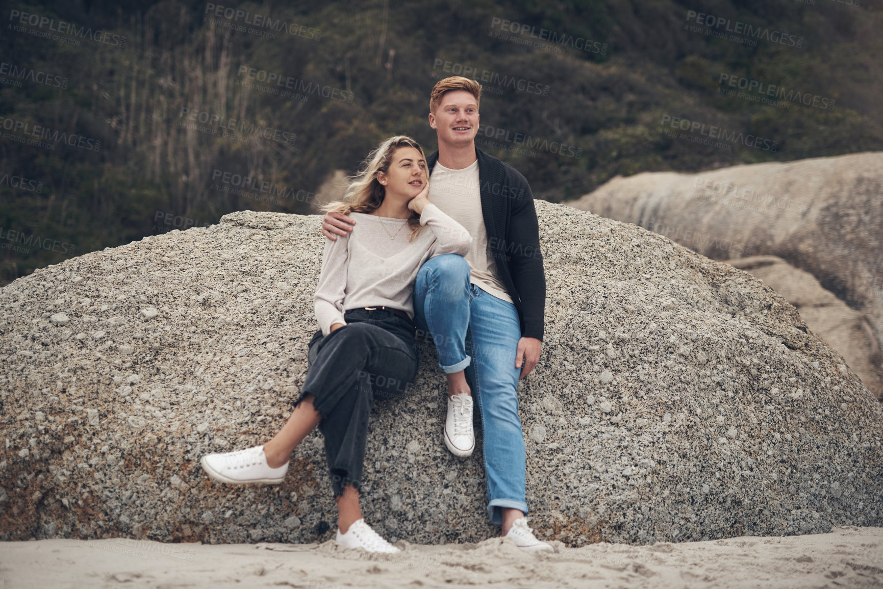 Buy stock photo Shot of a young couple spending the day together at the beach