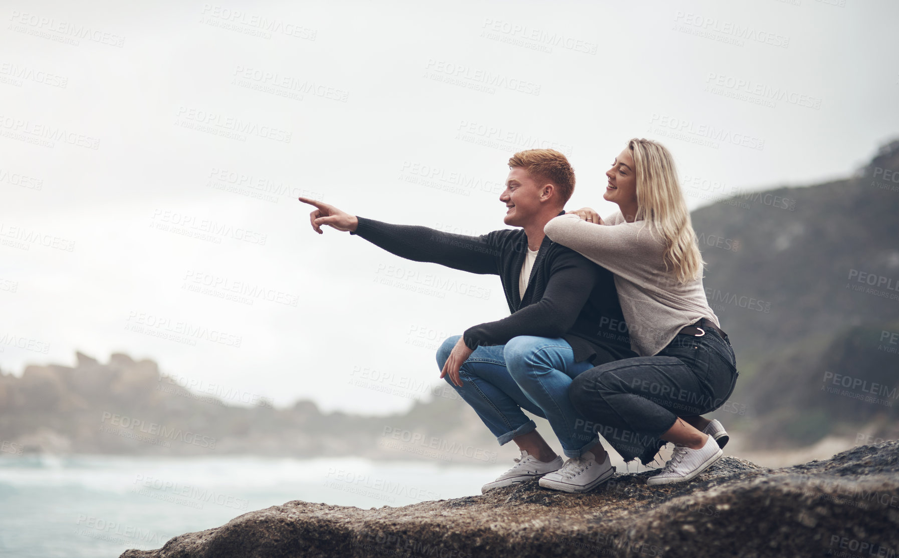 Buy stock photo Shot of a young couple spending the day together at the beach