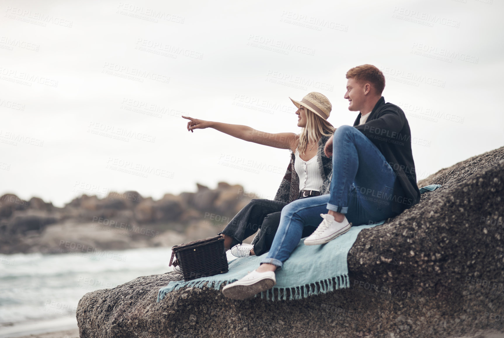 Buy stock photo Shot of a man taking pictures of his girlfriend while spending time at the beach