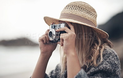 Buy stock photo Shot of a young woman out at the beach with her camera