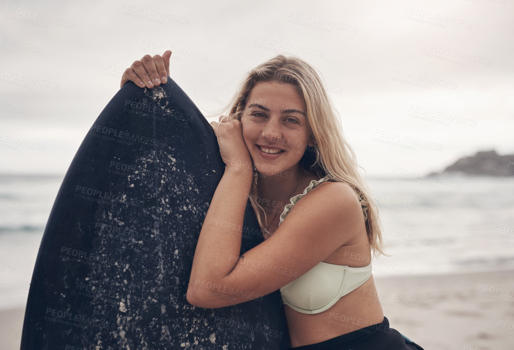 Buy stock photo Cropped shot of a young woman standing on the beach with her surfboard