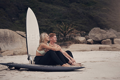 Buy stock photo Shot of a couple out at the beach with their surfboards