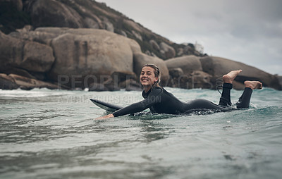 Buy stock photo Shot of a young woman out surfing at the beach